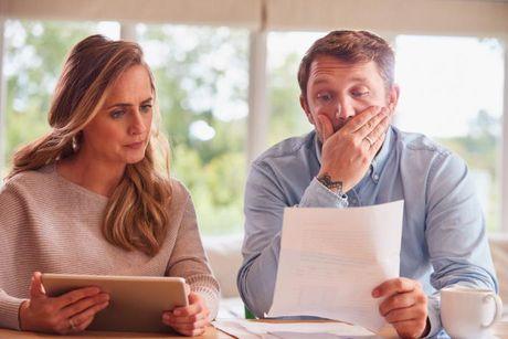 A couple looking at their documents feeling worried about their overdraft and credit rating.