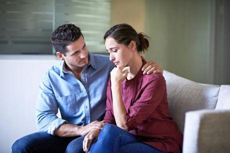 A man comforting his wife who is feeling sad after she had default on her credit score.