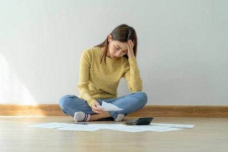 An image of a woman looking at her documents feeling confused trying to figure out what does adverse credit mean.