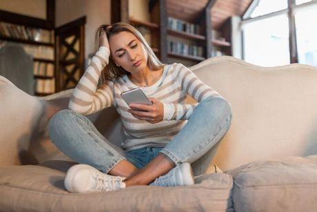 A young woman searching how to get a loan without a credit check on her phone.